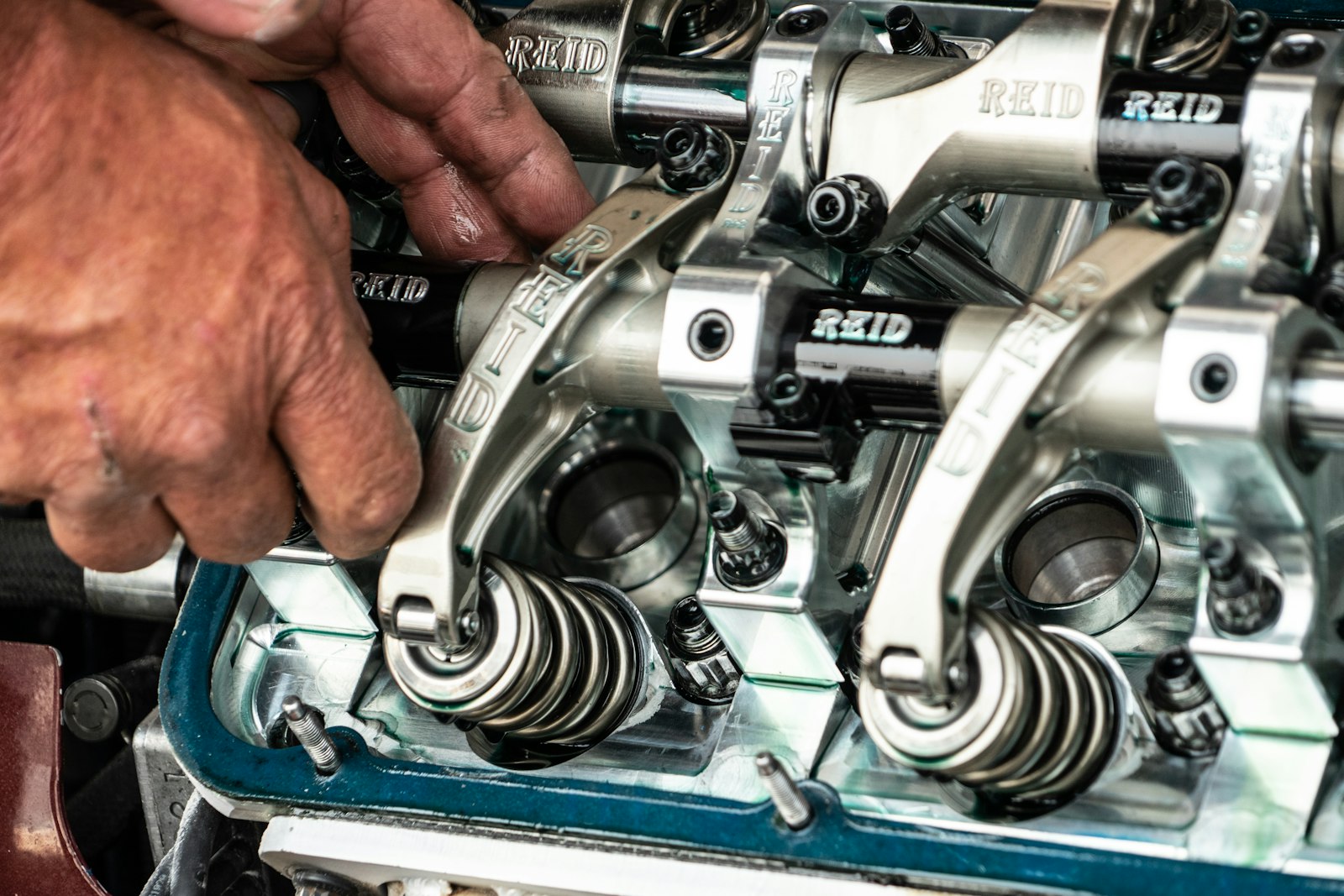 Hands servicing a marine engine's valve gear